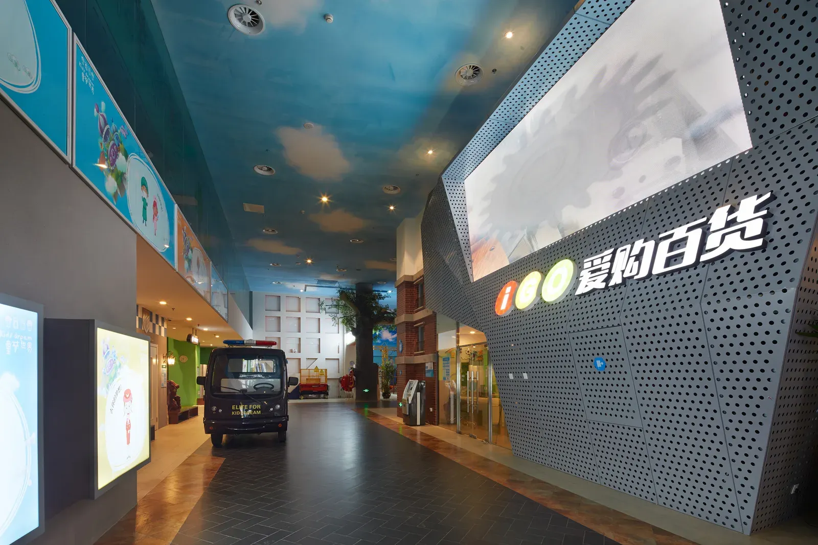 Department store with a perforated metal facade and a large display screen