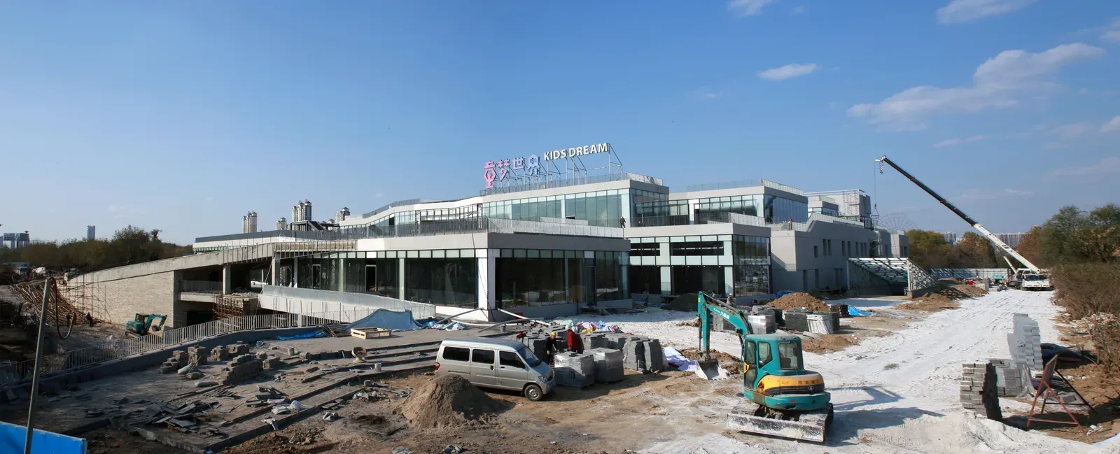 Panorama of the building under construction, with Kids Dream signage on the roof