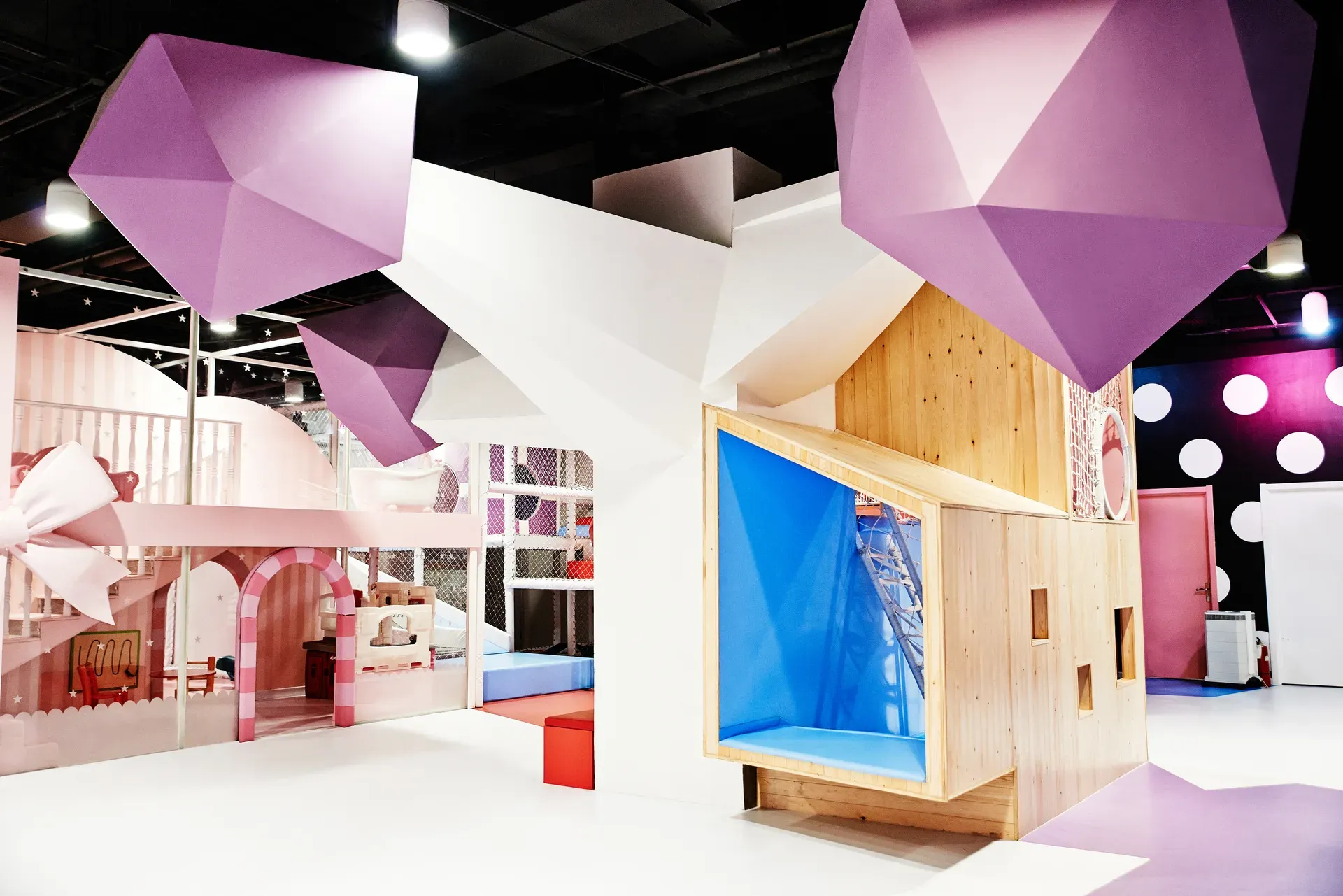 Faceted white tree columns with pink low-poly canopies above a dining area and a timber play house