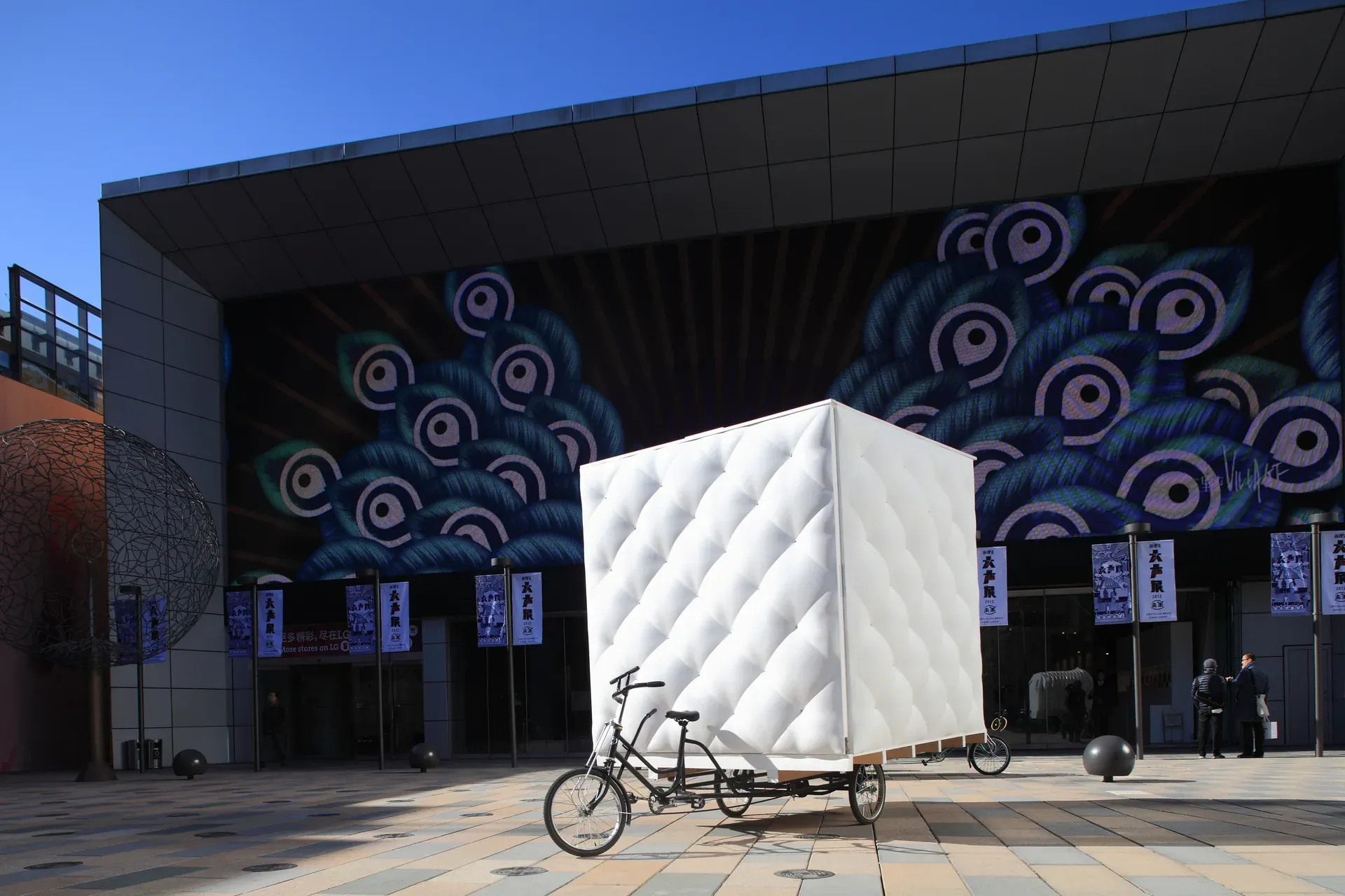 Bao House parked in a Beijing street at dusk, its white foam skin glowing